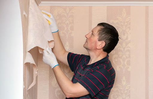 man removing wallpaper | how to remove wallpaper