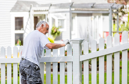 old man painting fences | staining wood